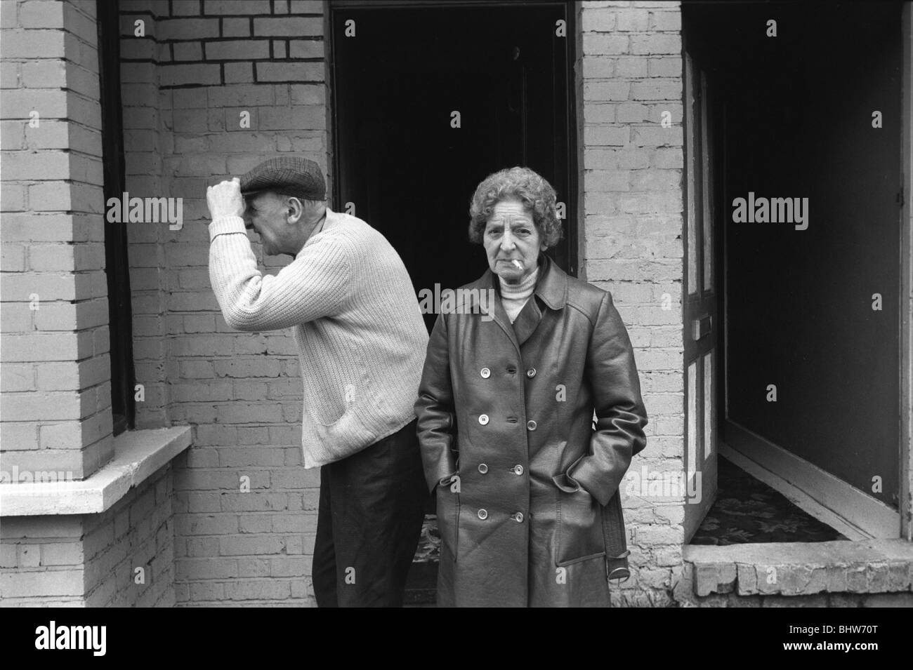 Älteres Arbeiterpaar im Norden Londons vor ihrem Haus. Sie raucht. 1970S UK 1977 HOMER SYKES Stockfoto