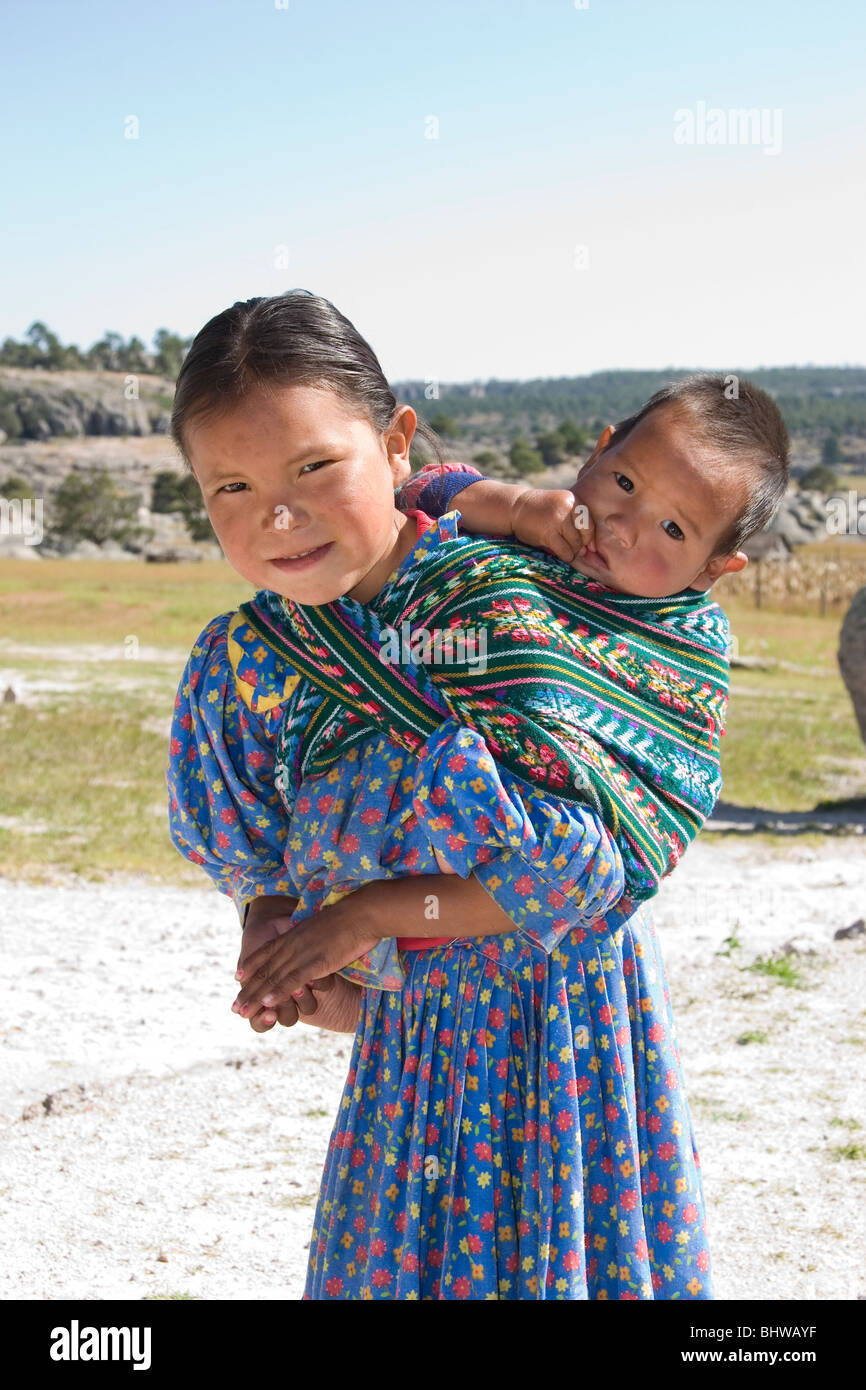 Tarahumara Kind trägt ein Baby auf ihrem Rücken, Copper Canyon Staat Chihuahua, Mexiko. Stockfoto