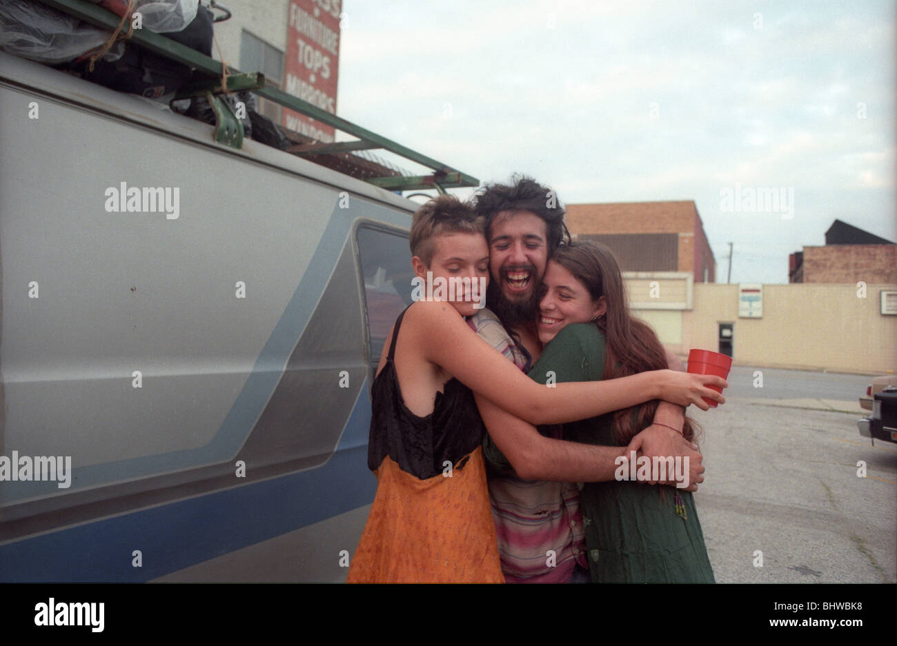 Drei Hippies umarmen außerhalb unendliche Sonne Gemeinde Innenstadt von Kansas City, Missouri. Stockfoto