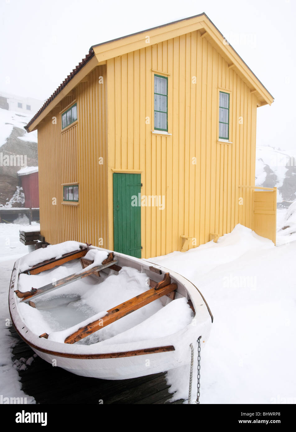 Gelb aus Holz Bootshaus in traditionellen Fischerdorf Smogen im Winter nach Schnee auf Bohuslan Küste in Schweden Stockfoto