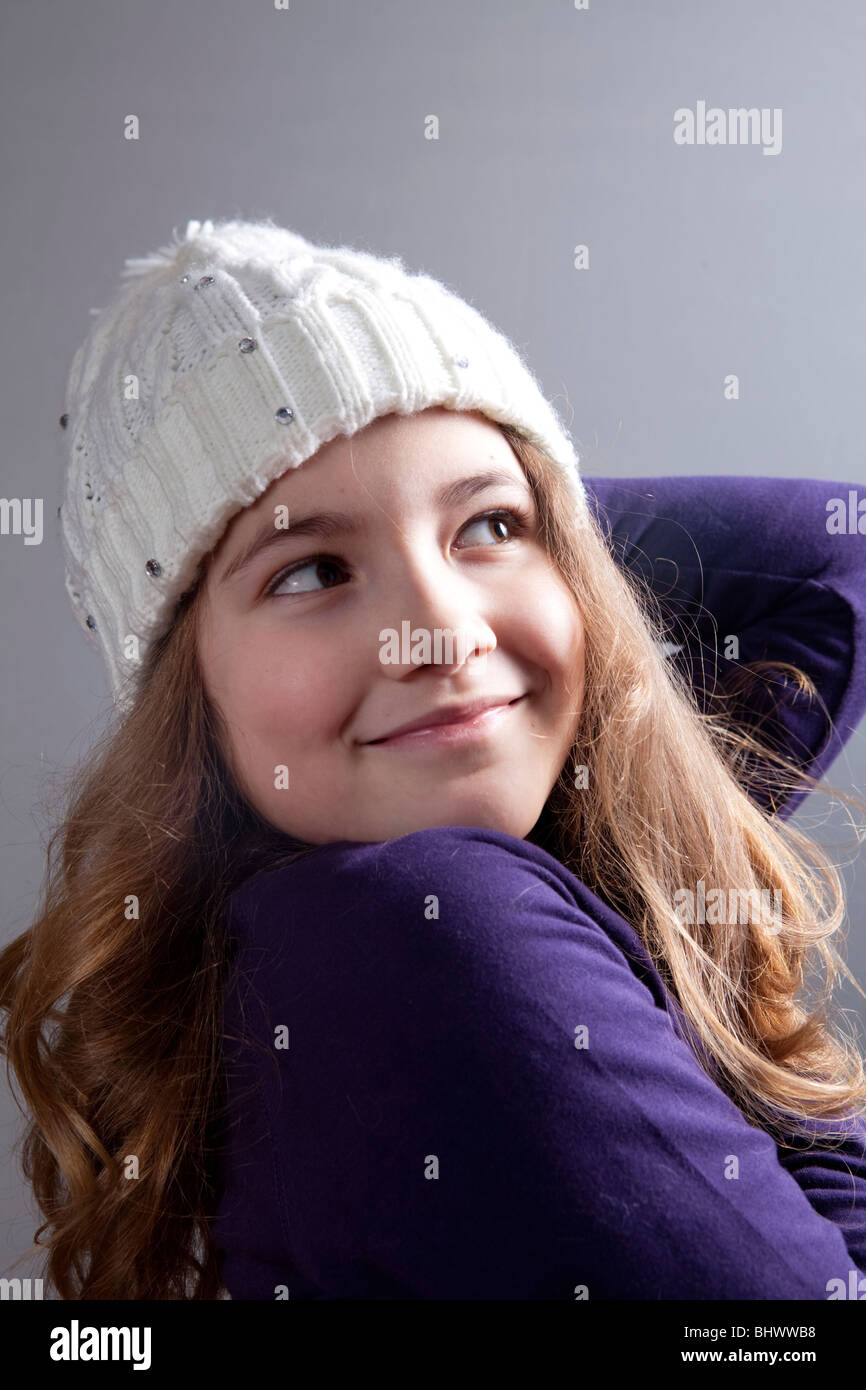 Studioaufnahme von einem kaukasischen Mädchen trägt Wollmütze und lächelnd Stockfoto