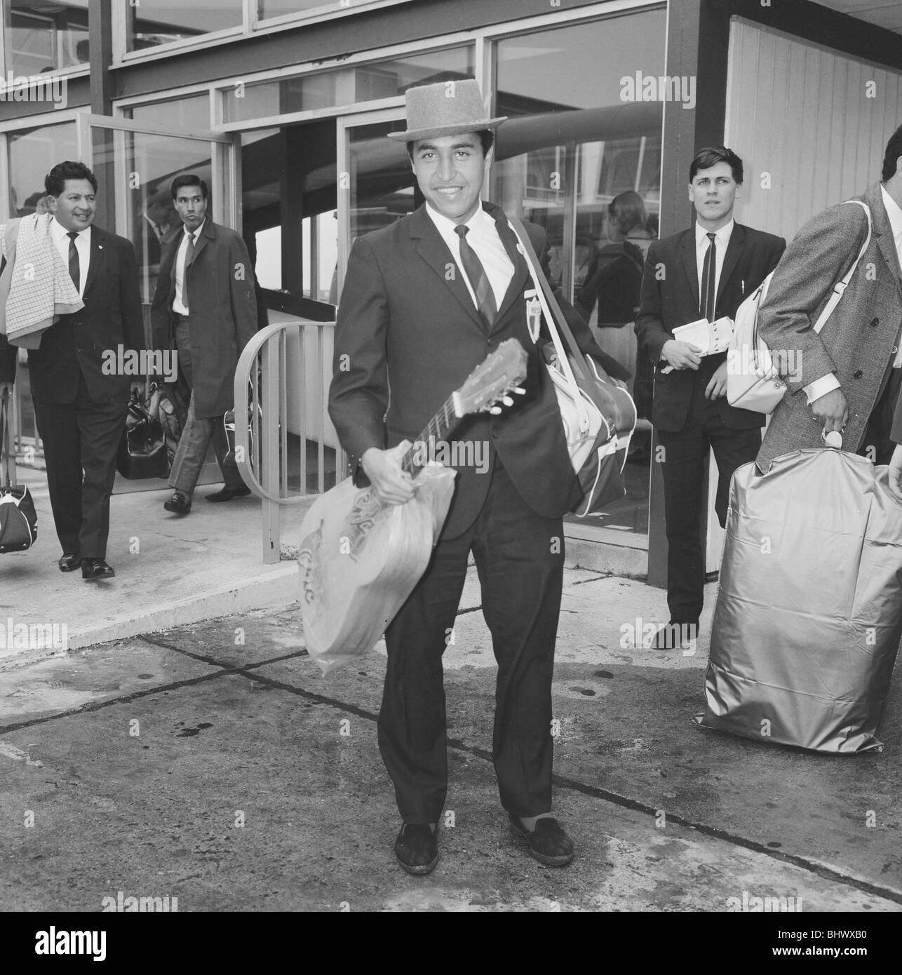 1966-World-Cup-Turnier in England. Hälfte zurück Dias von Mexiko WM-Team mit seiner Gitarre und trägt einen grauen Hut mit umgedrehten Krempe als das Team zurück zum Flughafen für ihren Flug nach Hause nachdem er aus dem Turnier ausgeschieden. 15. Juli 1966. Stockfoto