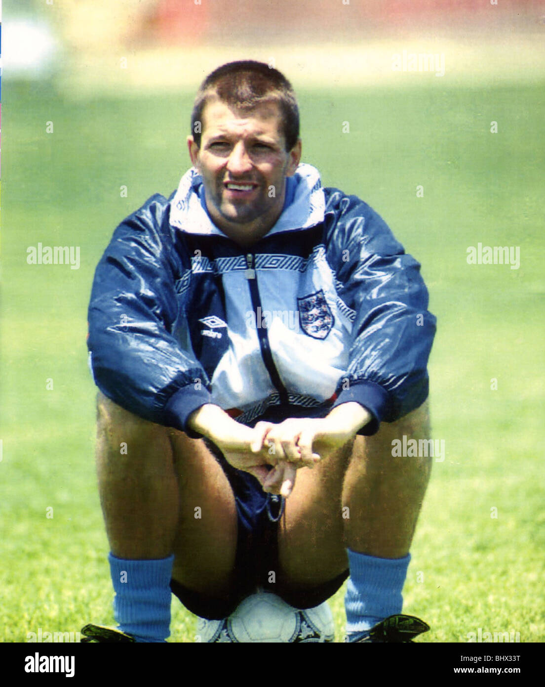 England Fußballer Steve Bull sitzt auf einem Fußball als er eine Pause von der Trainingseinheit in Italien während der WM 1990 nimmt. 14. Juni 1990. Stockfoto