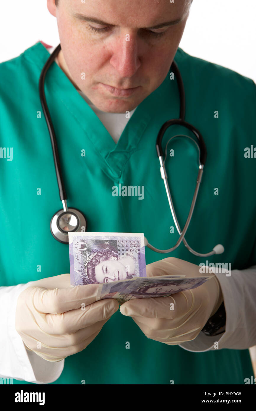 Mann trägt medizinische Peelings und Stethoskop 20 Pfund Sterling Banknoten zählen Stockfoto