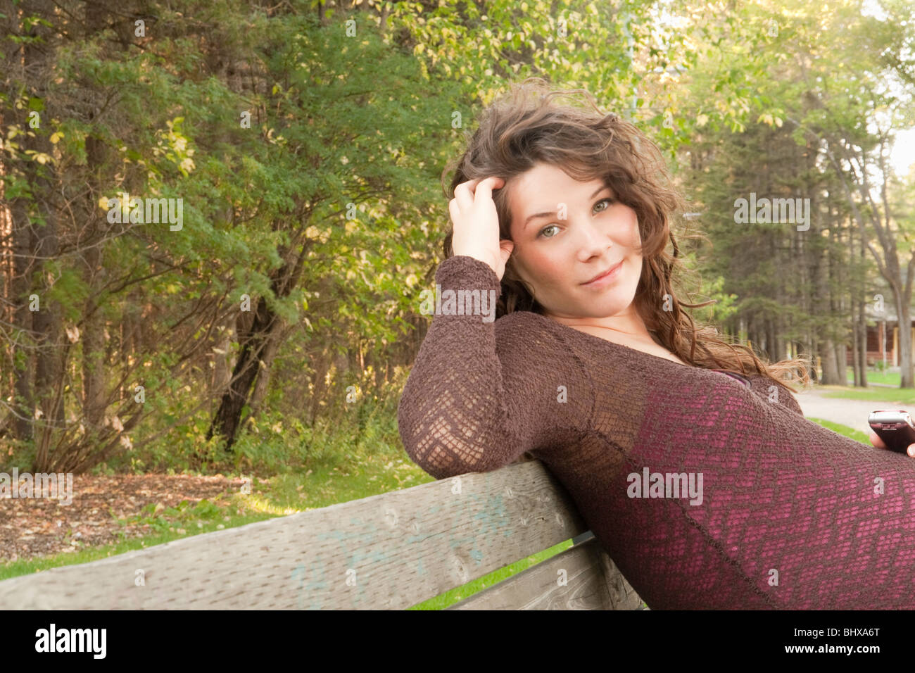 Schwangere Frau sitzend auf einem Park Bench, Manitoba, Kanada Stockfoto