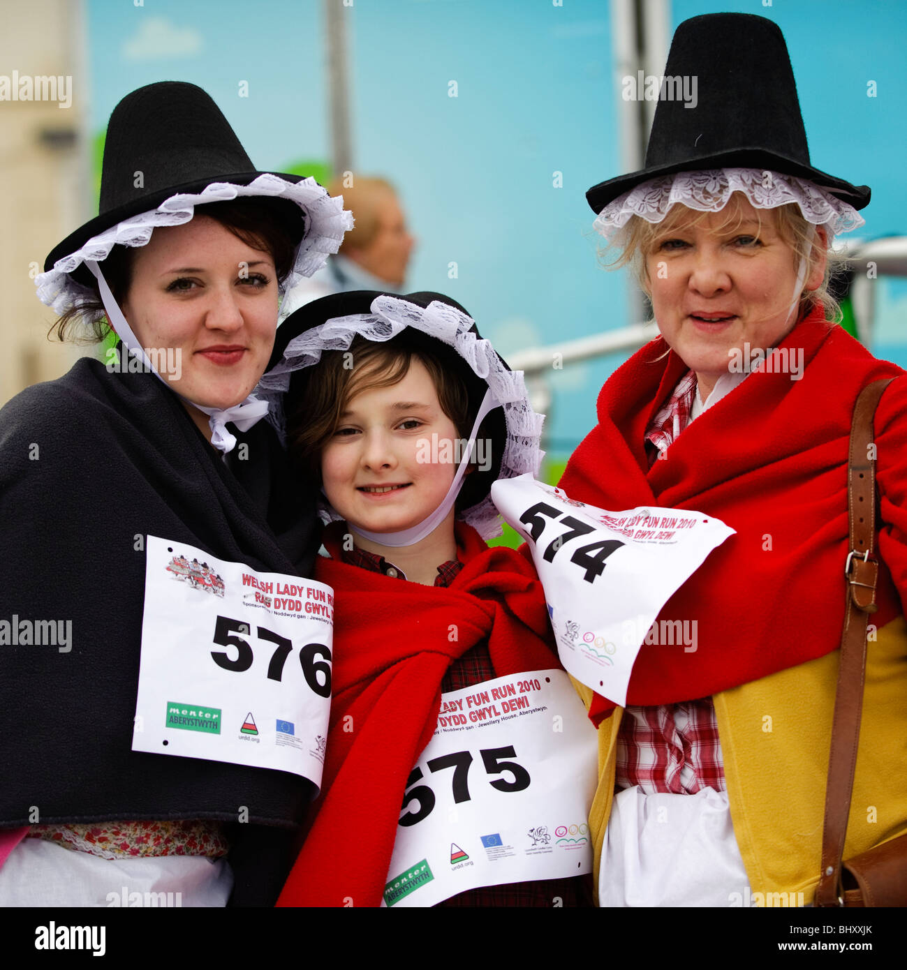 Drei Frauen in Tracht, die im Wettbewerb mit der Welsh Lady Charity gesponsert Volkslauf, St Davids Day, Aberystwyth Wales UK Stockfoto