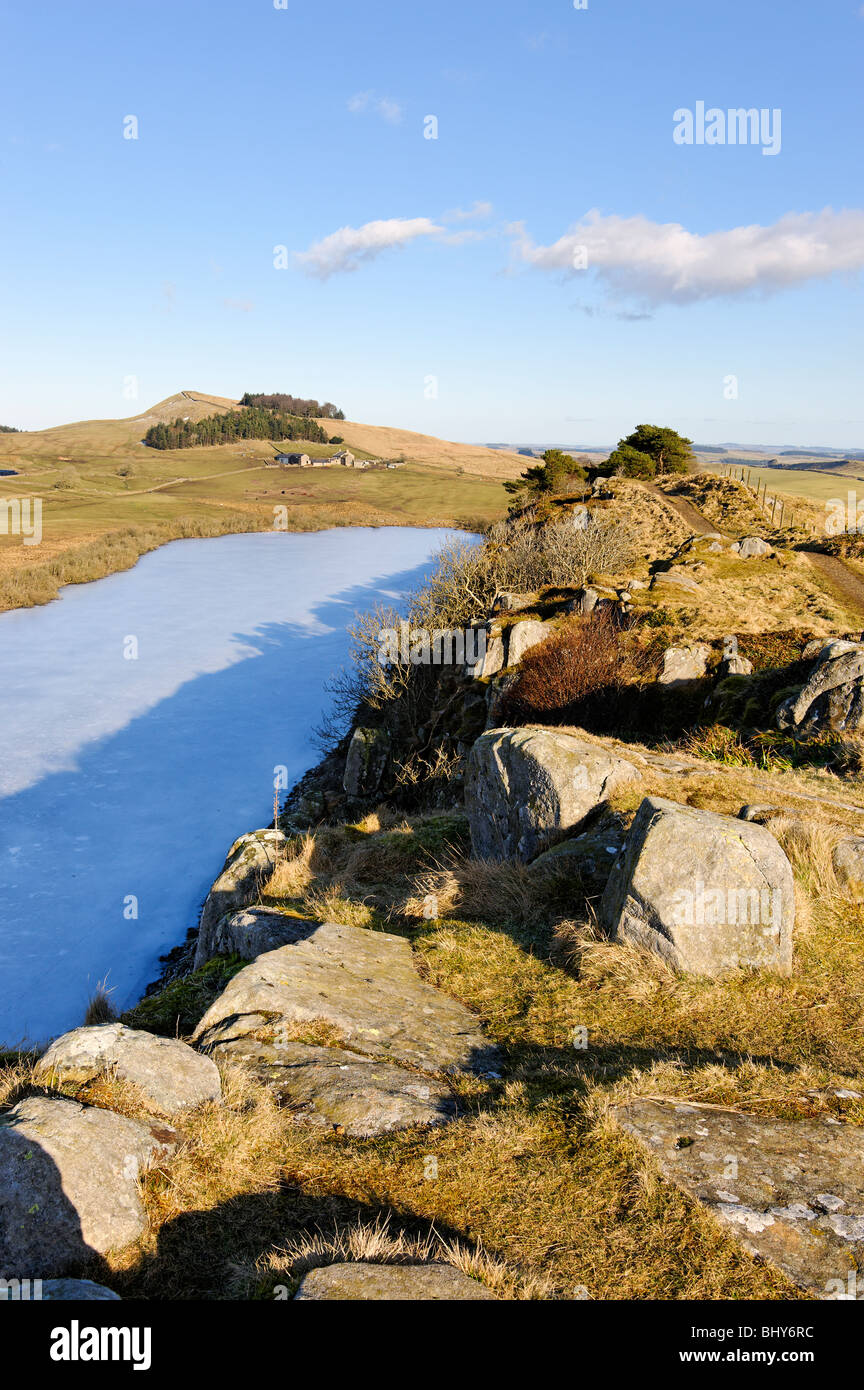 Auf der Linie der Hadrianswall blickte von Highshield Klippen an gefrorenen Felsen Lough. Stockfoto