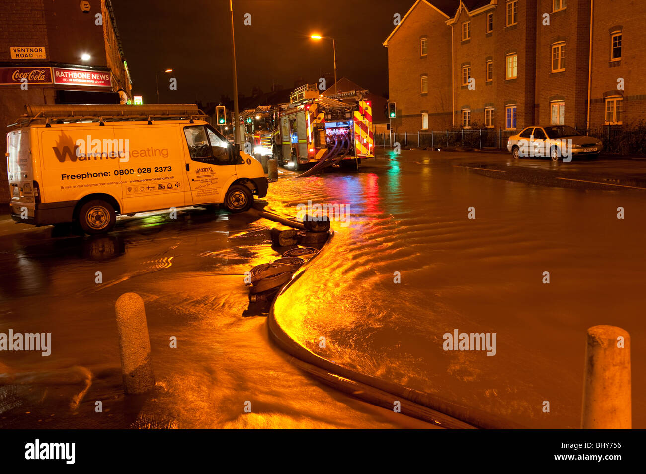 Feuerwehrauto Pumpen aus überfluteten Straßen und Häuser in der Nacht Stockfoto