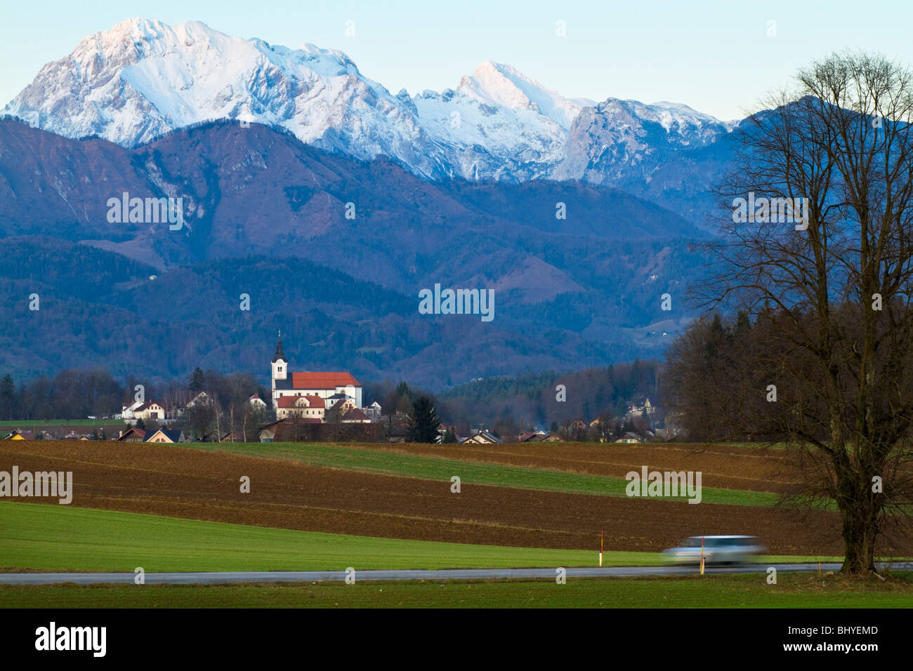 Die Kirche der Komenda, Slowenien mit der Kamnik Alpen droht sich dahinter. Stockfoto