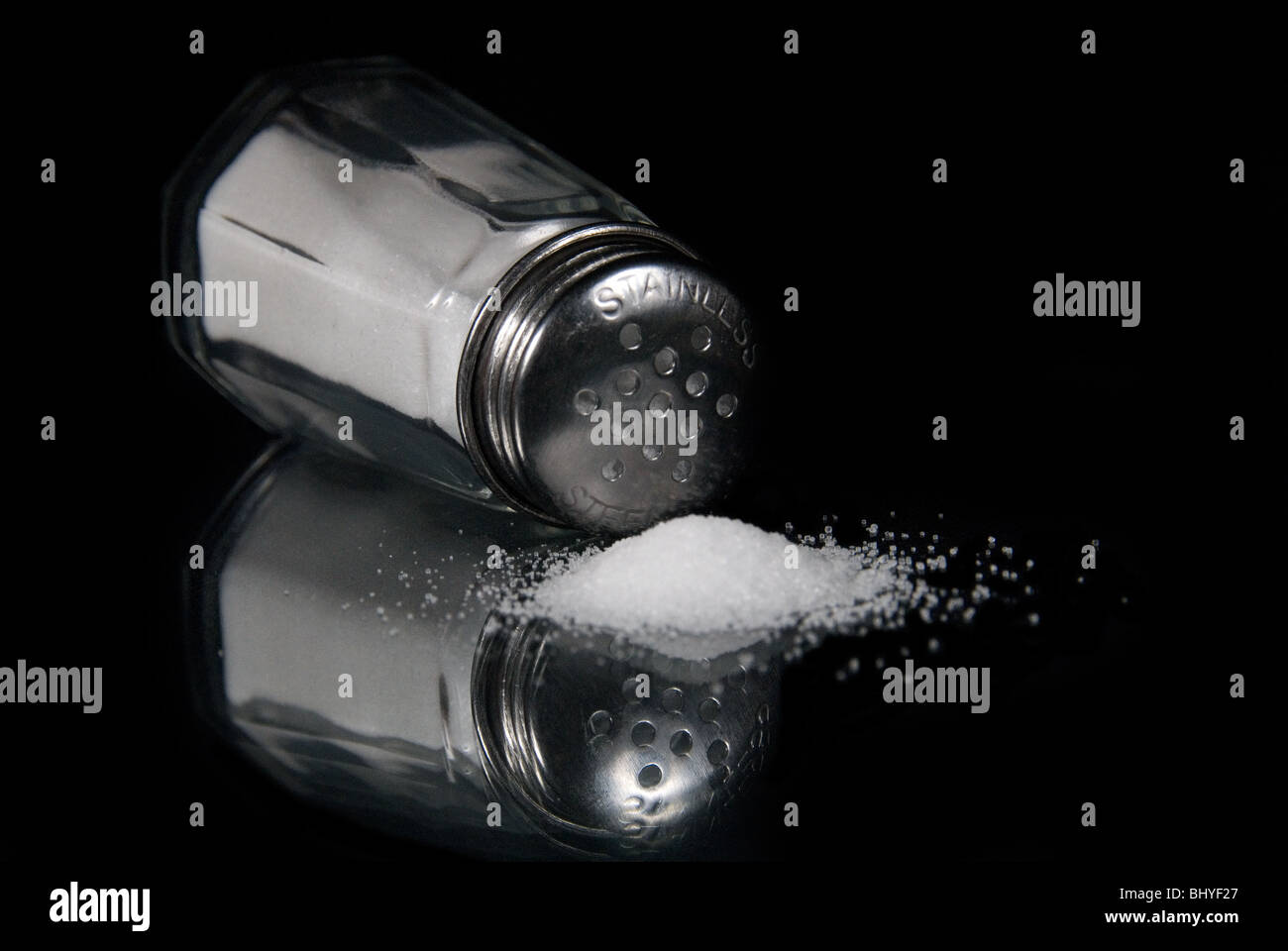 Ein Salzstreuer Glas umgeworfen mit Salz austreten Stockfoto