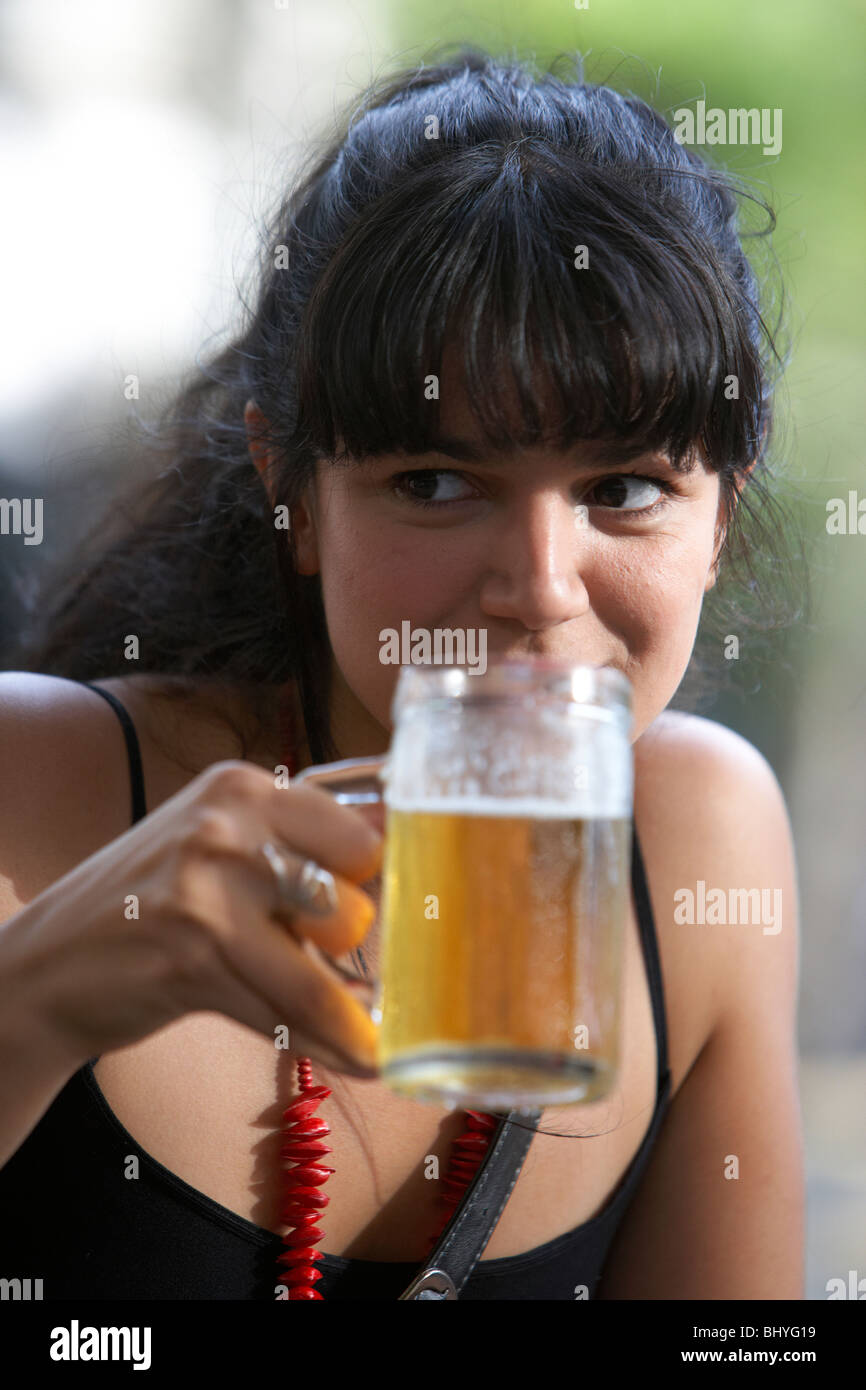 Mitte der zwanziger Jahre hispanic Frau trinkt ein Glas Bier in einem Café im freien Tisch wegschauen Stockfoto
