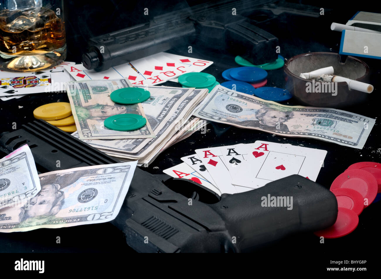 Waffen und Karten auf dem Tisch - Betrug beim Glücksspiel Stockfoto