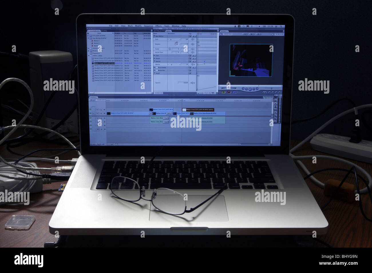 Graue Aluminium-Aluminium-Laptop-Computer mit Video-editing-Software und ein paar Lesebrille. Logos entfernt. Stockfoto