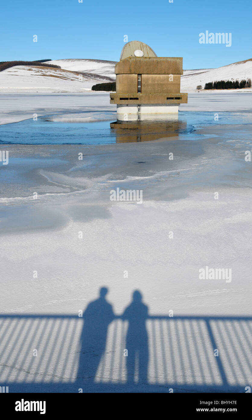 Schattierte Silhouette eines Paares auf Schnee bestäubt und gefrorenen Reservoir. Stockfoto