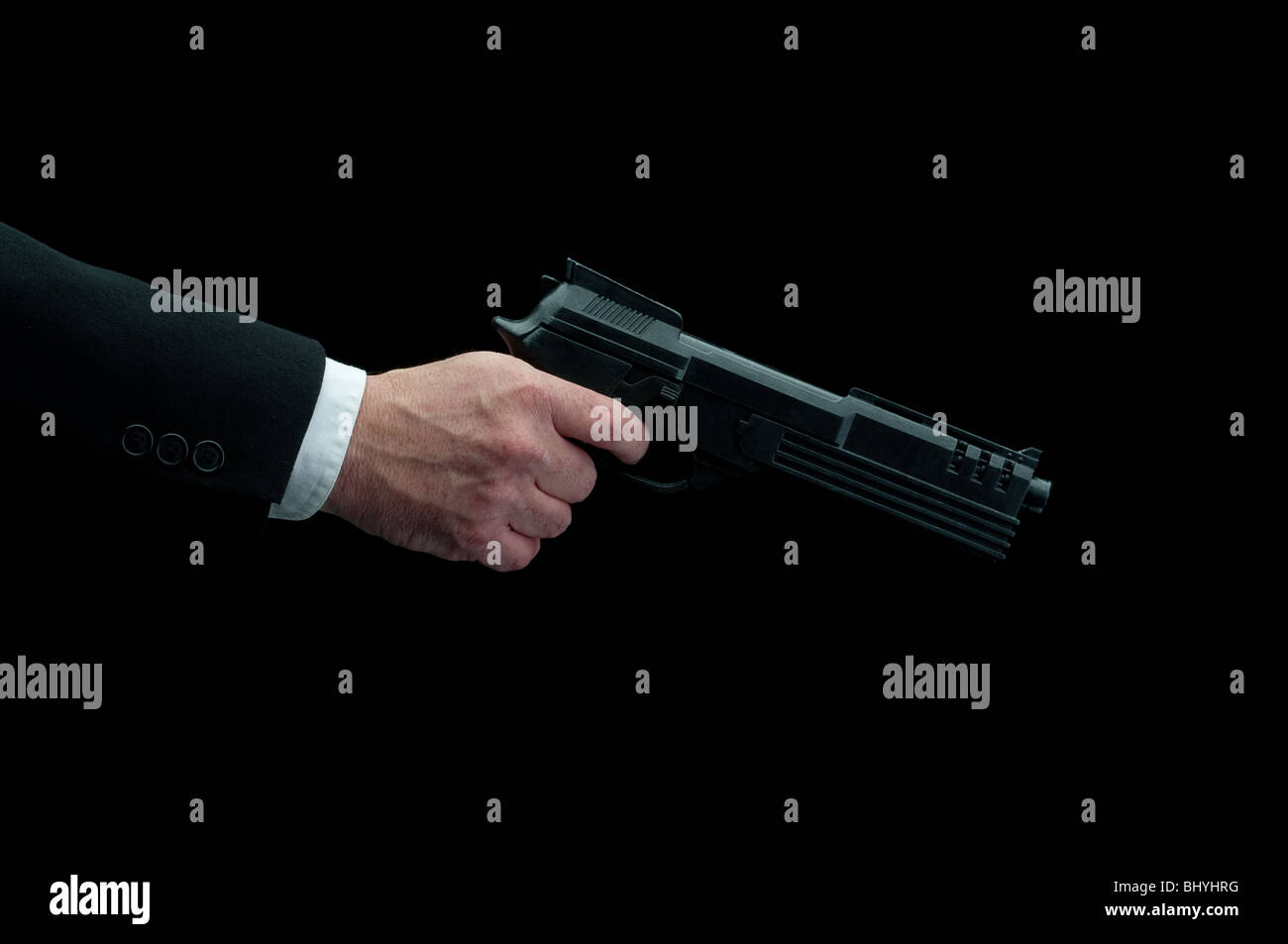ein Mann im Anzug Abfeuern einer Pistole auf schwarz Stockfoto