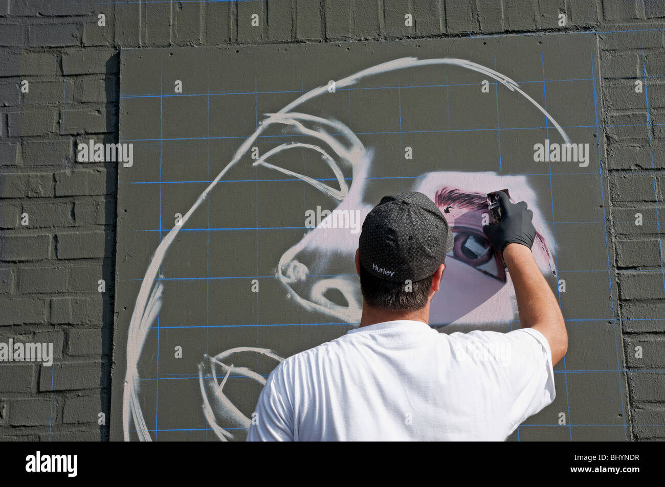 Professionelle Graffiti Künstler Spritzlackierung eine Figur auf der Außenseite eines Ladens. Stockfoto