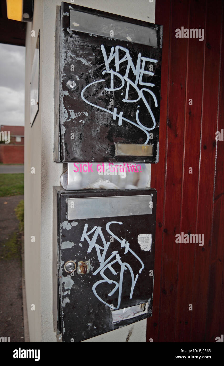 Zwei verwüstet Briefkästen außerhalb Wohnungen in Hounslow, West London, UK.  Ein Magazin über Graffiti Gemeinderat ist sichtbar. Stockfoto