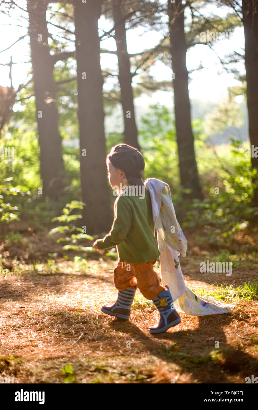 Kleiner Junge mit einer Decke in den Wald. Stockfoto