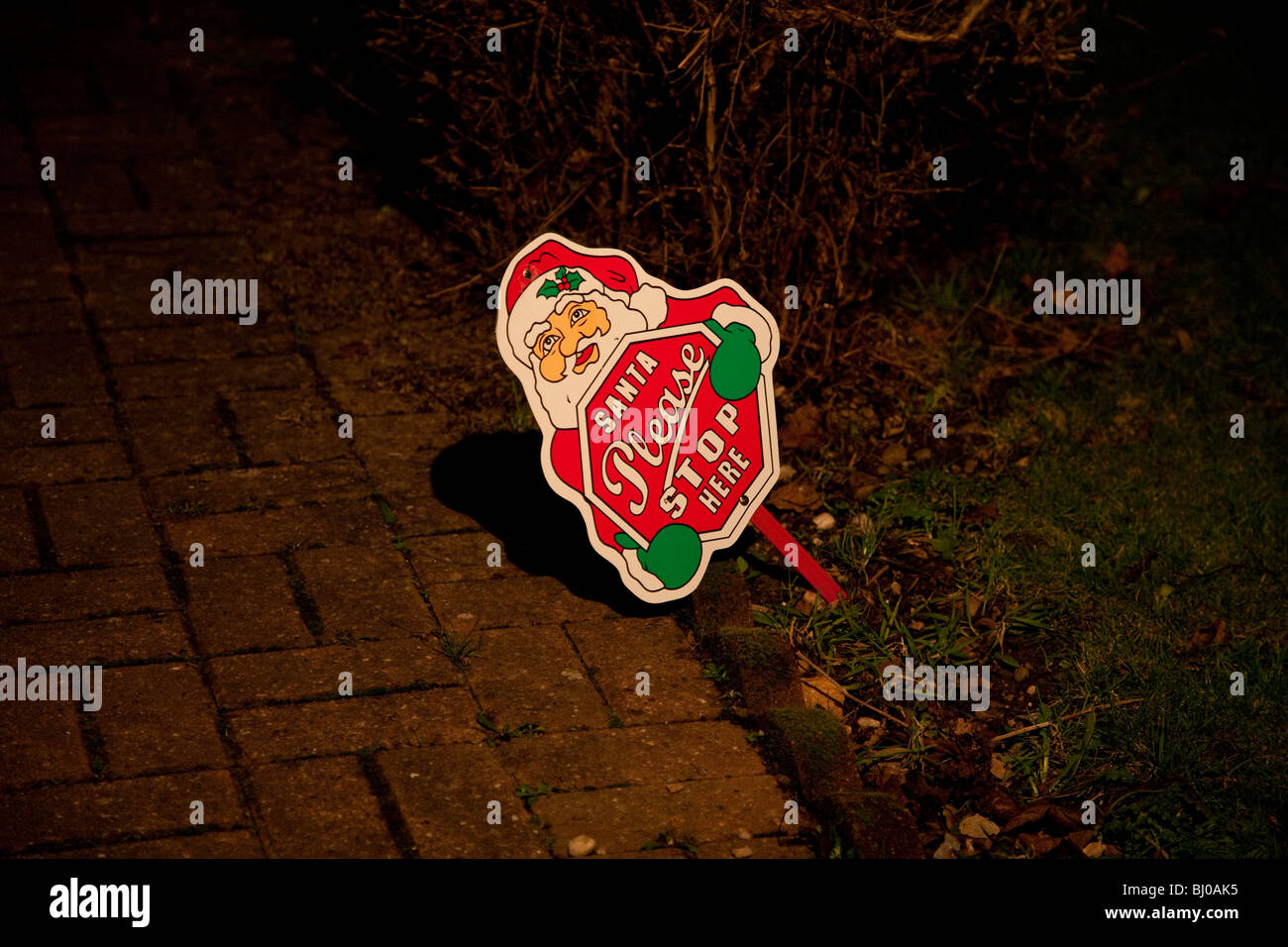 Santa Bitte Stop-Schild in den Boden an der Vorderseite des Photogrpahed ein Haus in der Nacht mit Blitz Stockfoto