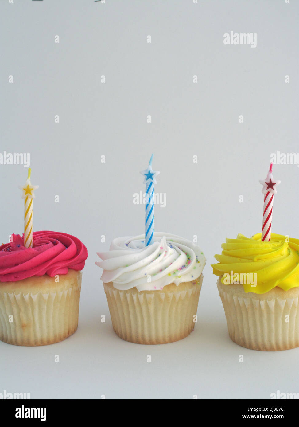 Drei bunte Cupcakes mit Kerzen Stockfoto