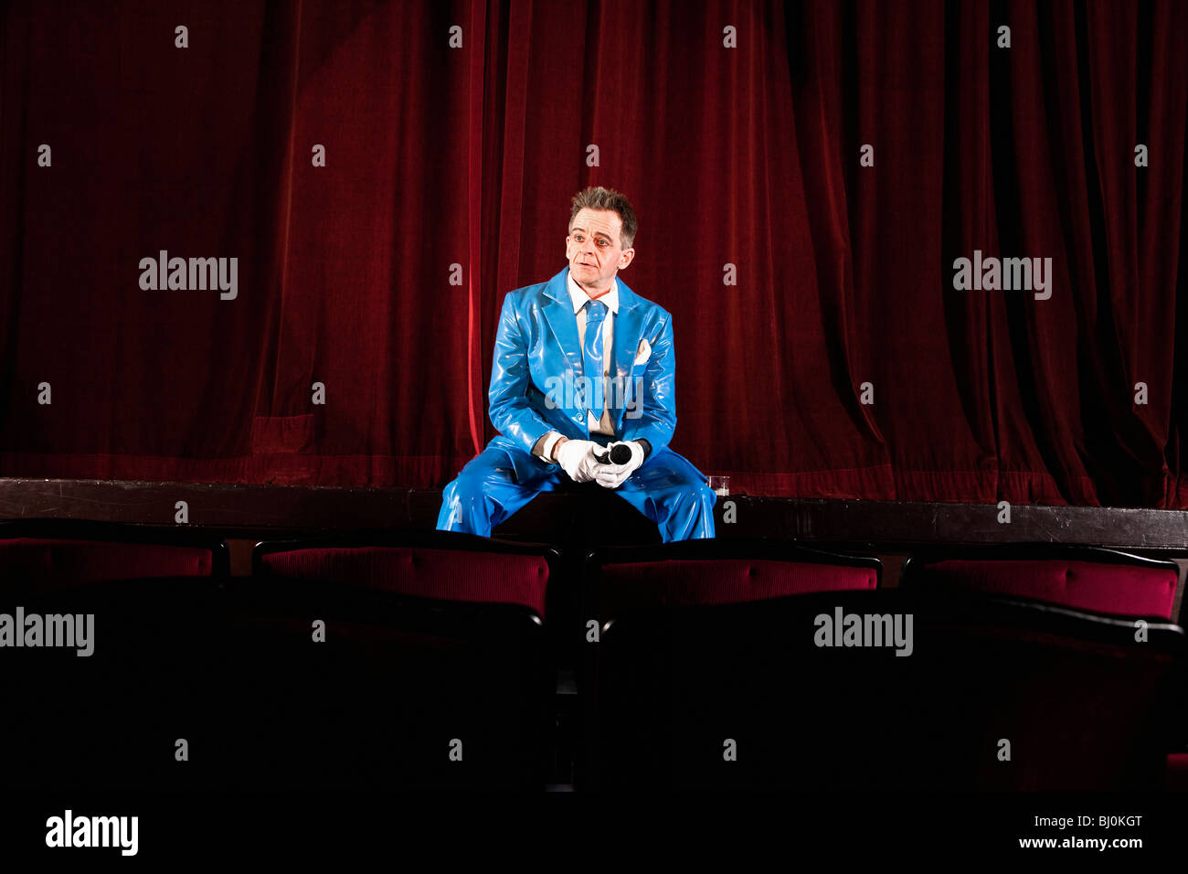 Komiker auf der Bühne sitzen Stockfoto