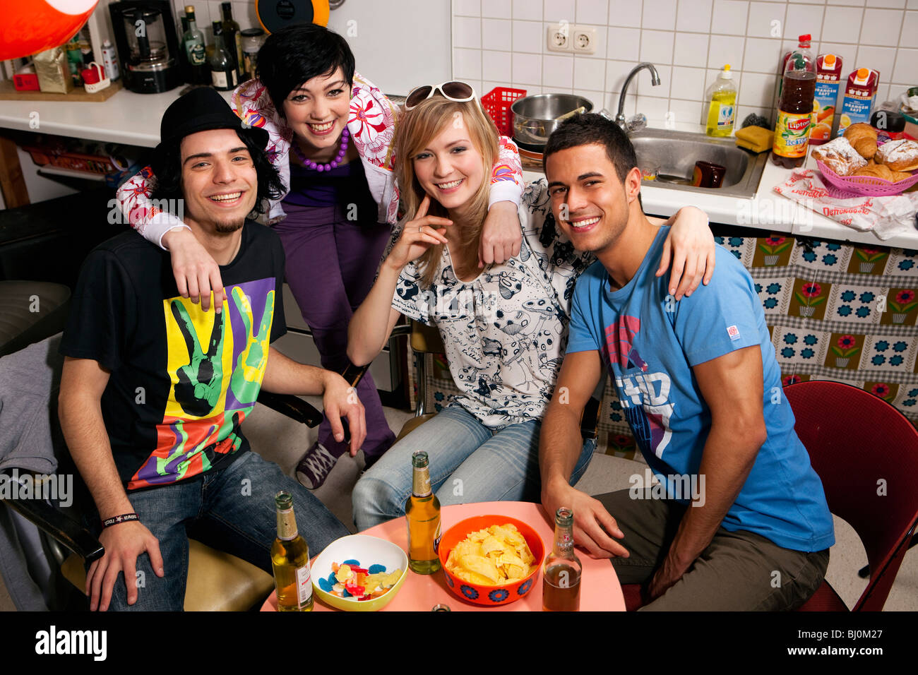 Gruppe von vier Freunden zusammensitzen in Küche Stockfoto