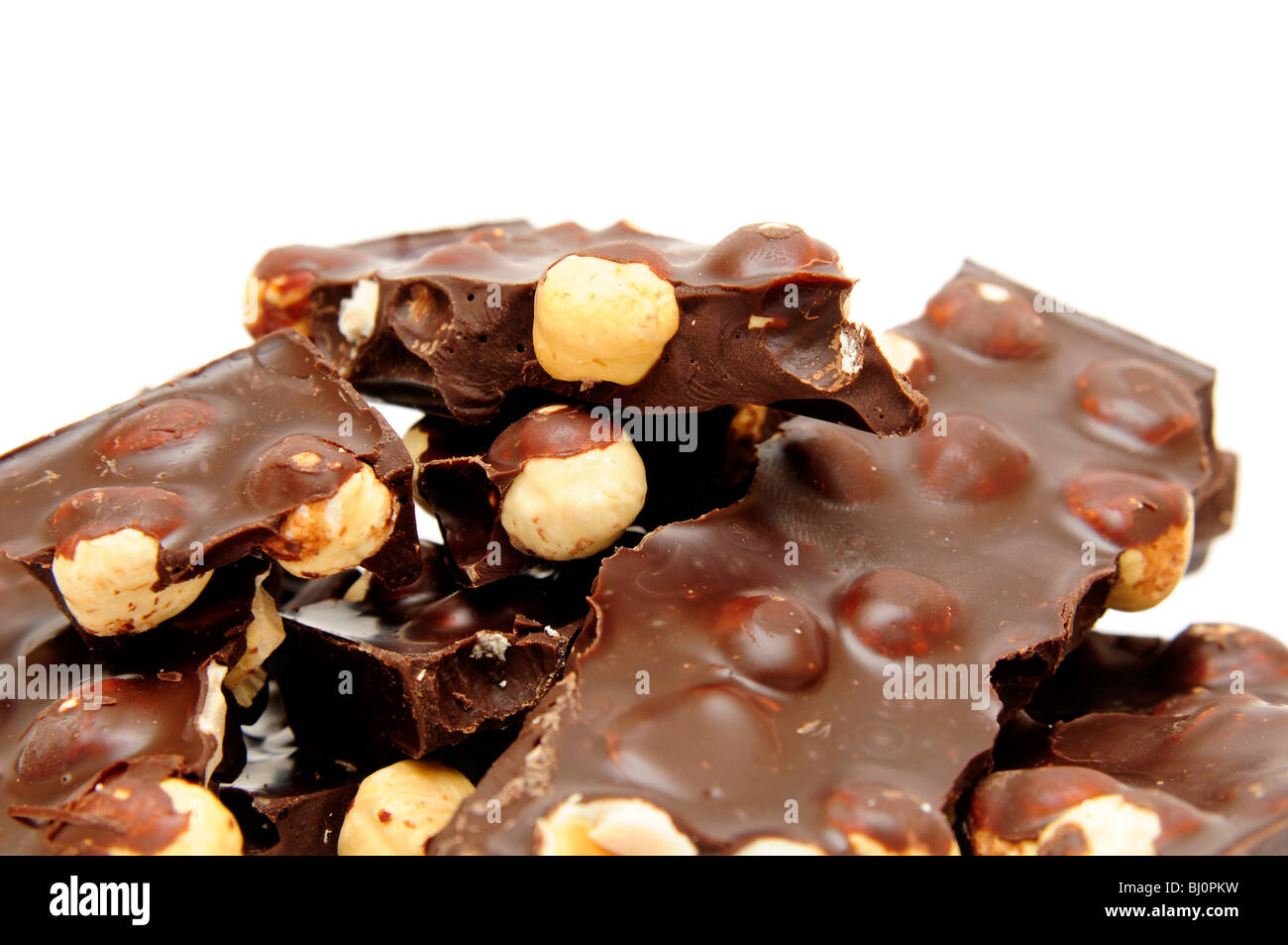 Schokolade mit Nüssen auf dem weißen Hintergrund isoliert. Stockfoto