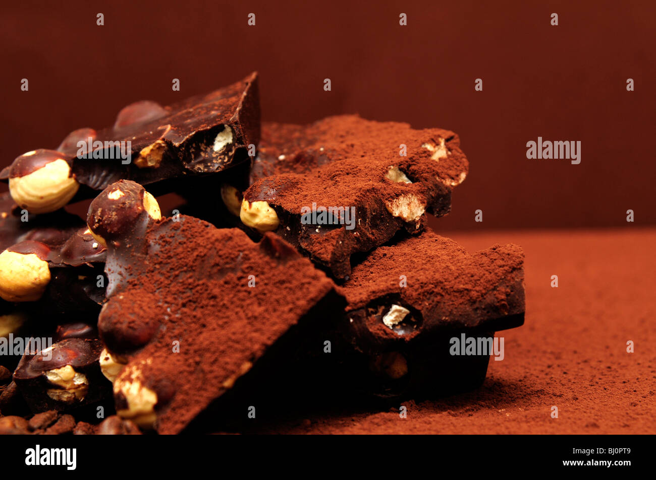 Schokolade mit Nüssen auf dem Kakao Hintergrund. Stockfoto