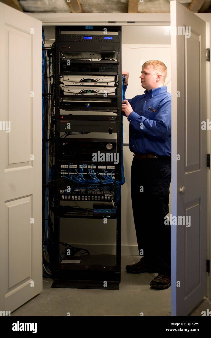 Techniker installiert Elektronik, die betreiben und home-Entertainment-System zu erarbeiten. Komponenten sind im Keller versteckt. Stockfoto