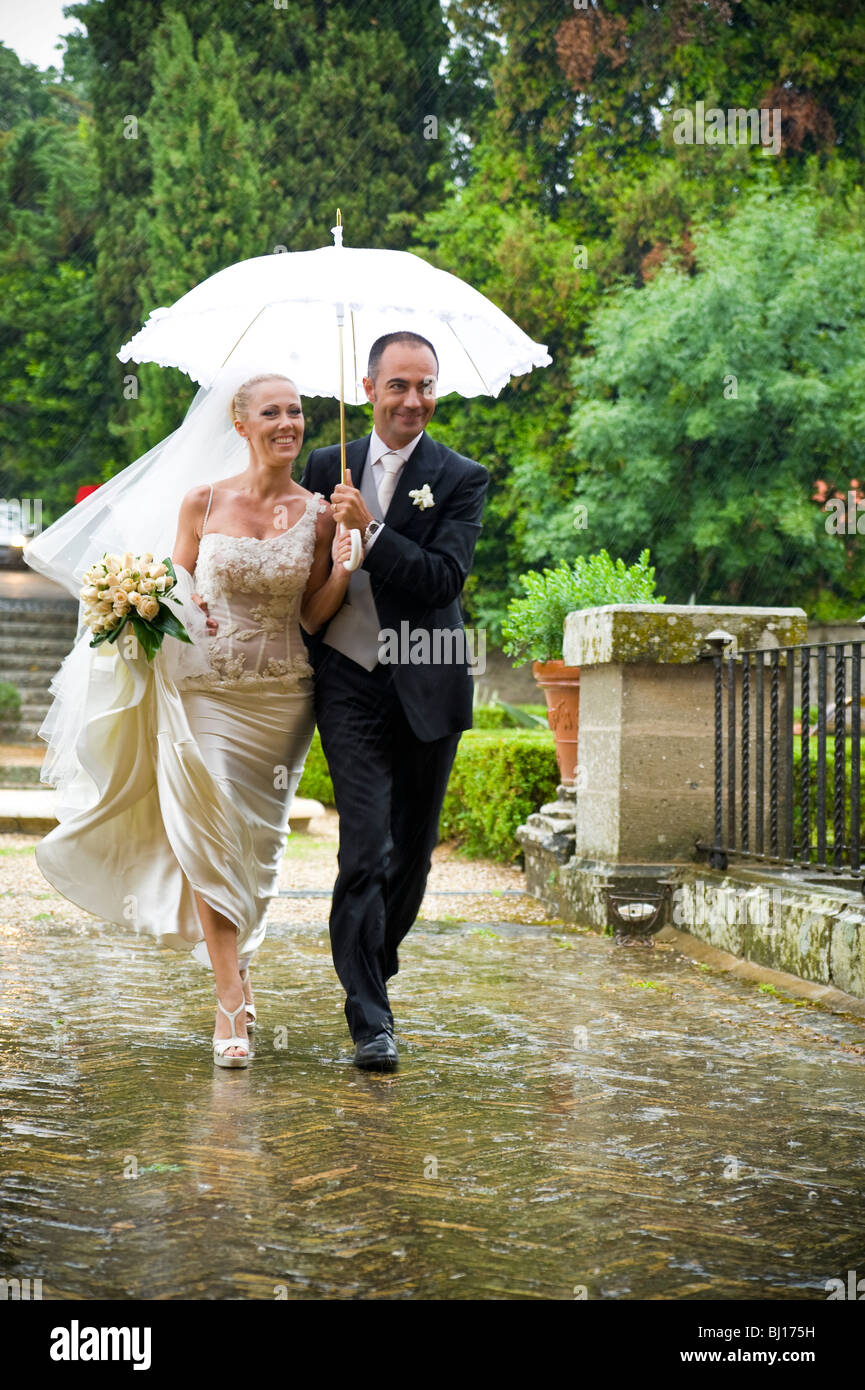 Paare, die mit Schirm im Regen Stockfoto