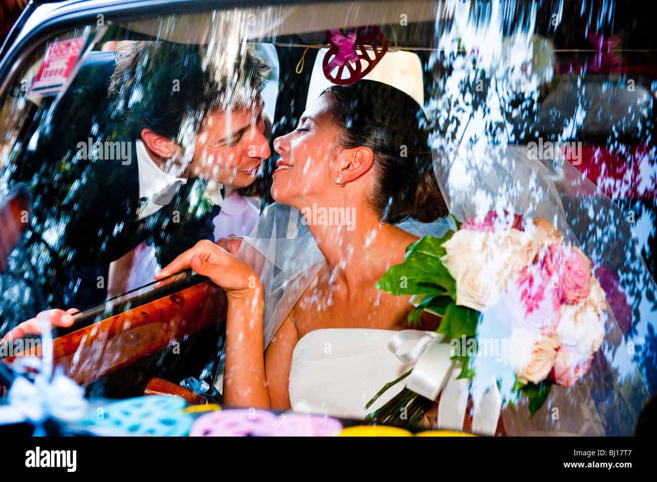 Braut und Bräutigam küssen in einem Auto Stockfoto