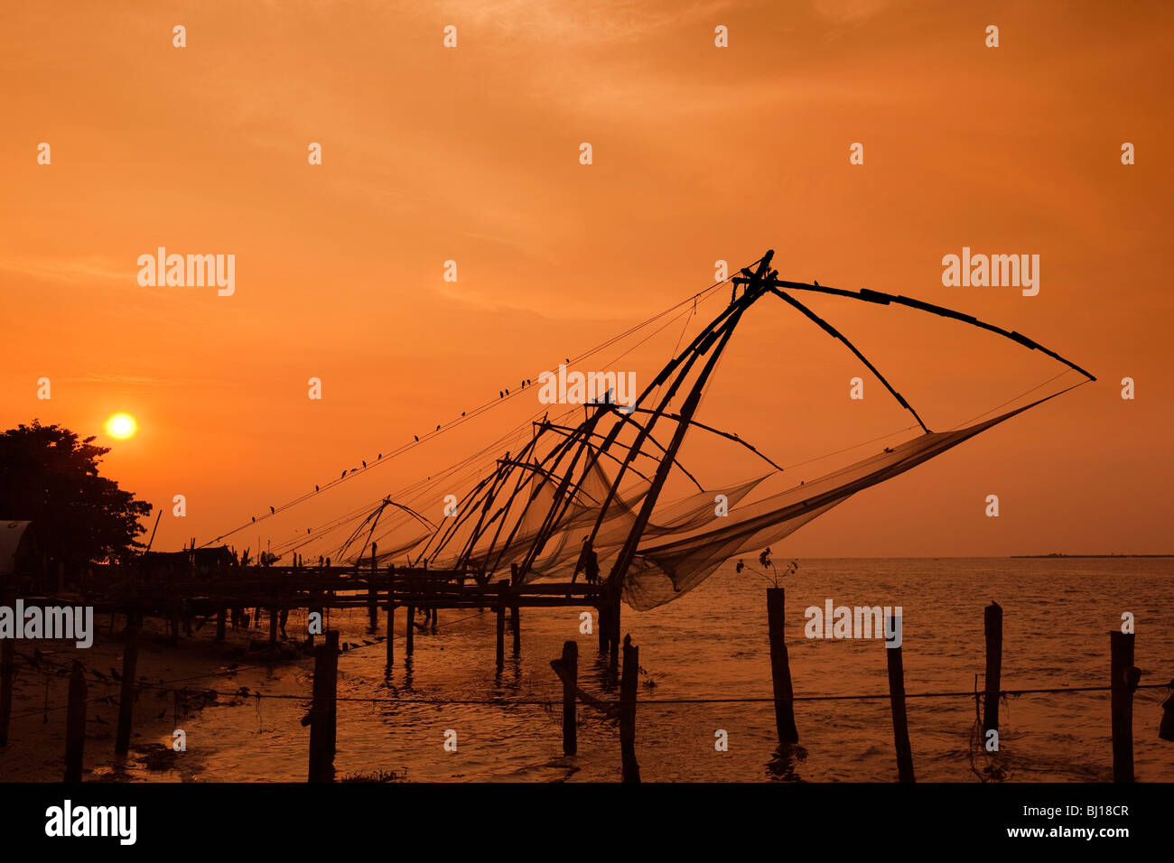 Indien, Kerala, Kochi, Fort Cochin, Strandpromenade, Chinesische Fischernetze bei Sonnenuntergang Stockfoto