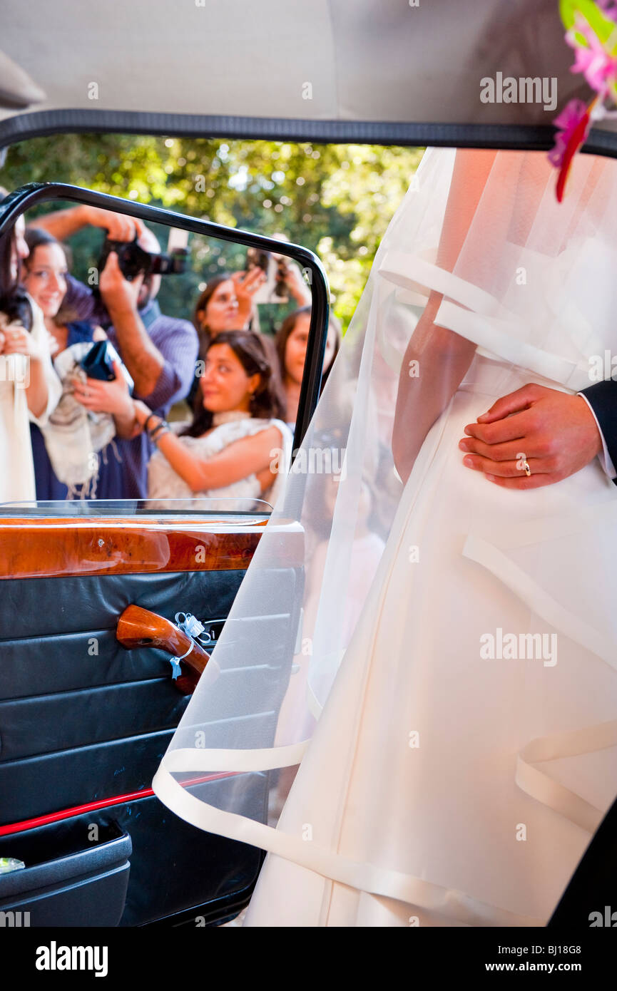 Braut und Bräutigam posiert für Fotos in der Nähe von Auto Stockfoto