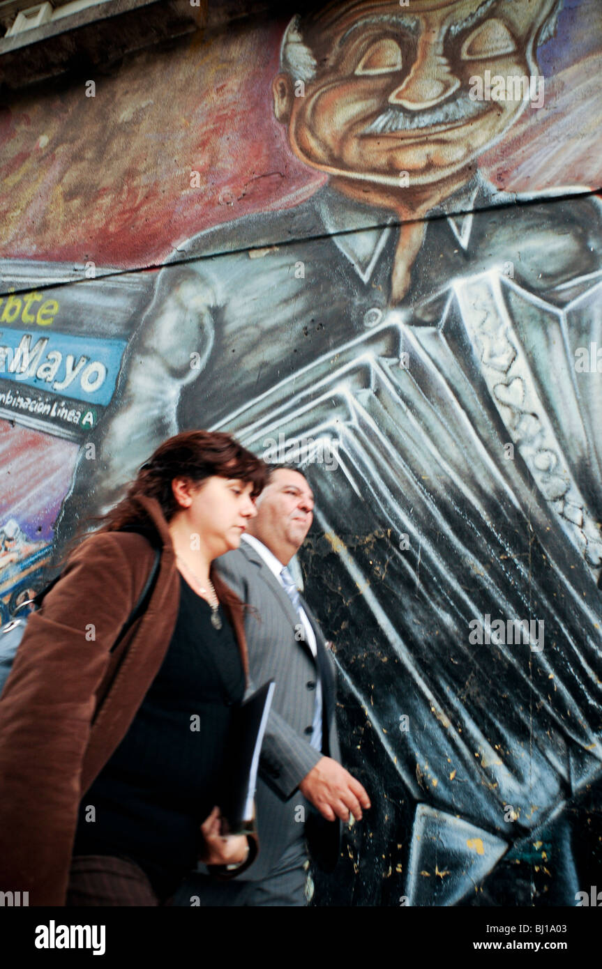 Paar vorbeigehen Wandbilder von Astor Piazzolla in einer zentralen Straße der Stadt Buenos Aires, Argentinien Stockfoto