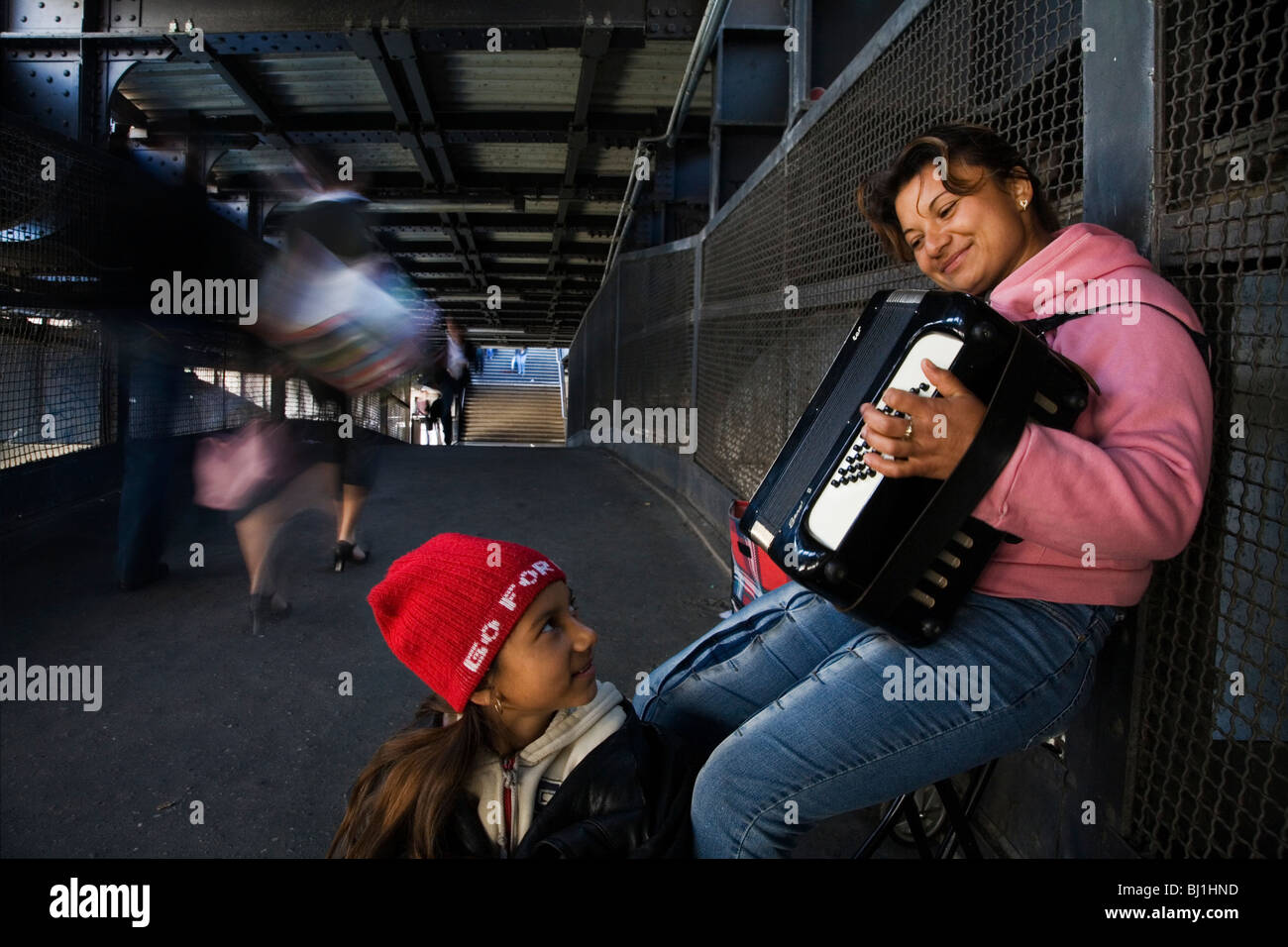 Straße Musiker: Rumänisch Exilspanier mit ihrer Tochter spielt Akkordeon an der Friedrichstrasse S Bahn Train Station Berlin, Deutschland Stockfoto