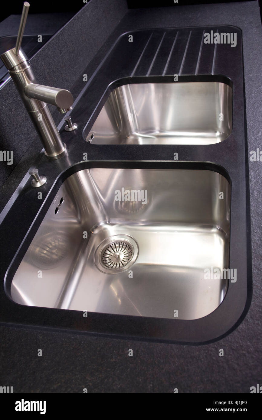 Stahl-Wasserhahn und Waschbecken in schwarz Küchentheke Stein Stockfoto