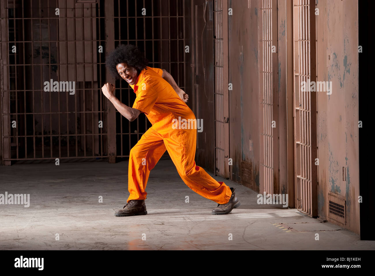 Ein schwarzer Mann mit einem Afro machen verschiedene Gesichter und Gesten in einem Bundesgefängnis Stockfoto