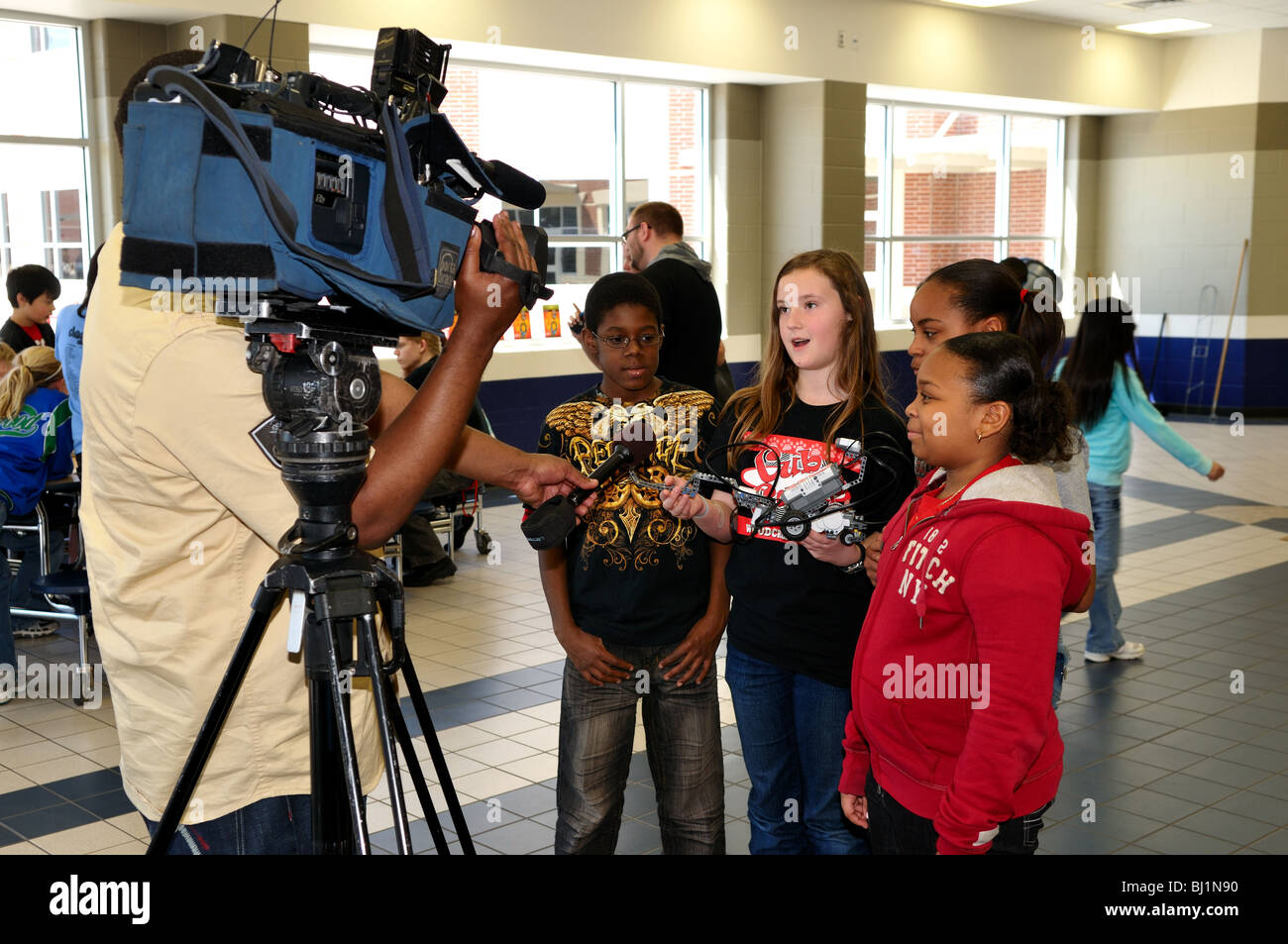 Eine Gruppe von Schulkindern sind von einem TV-Reporter während einer Wissenschaftsmesse interviewt. Stockfoto