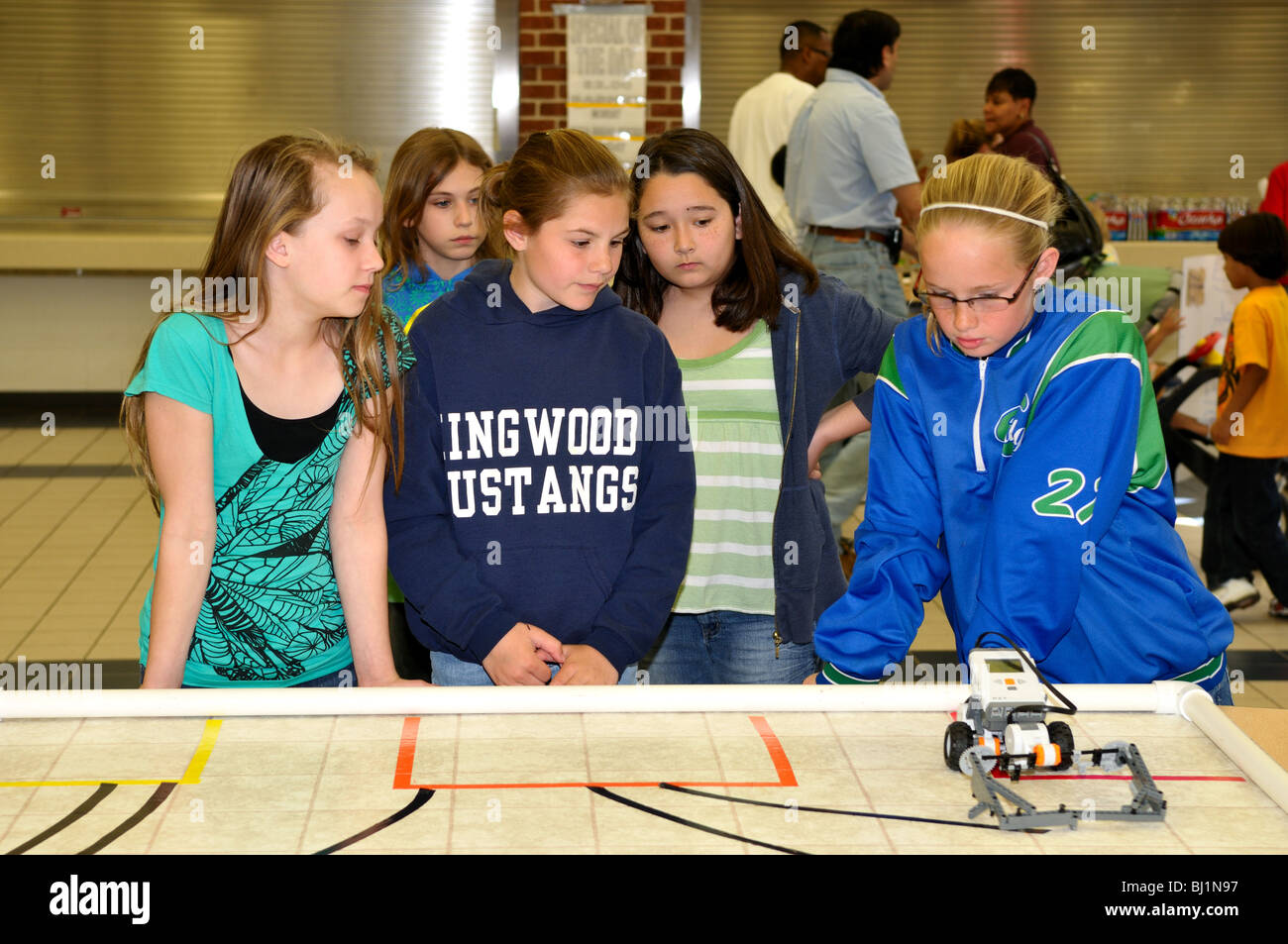Eine Gruppe von Schülerinnen an einem Roboter-Auto während einer Wissenschaftsmesse arbeiten. Stockfoto
