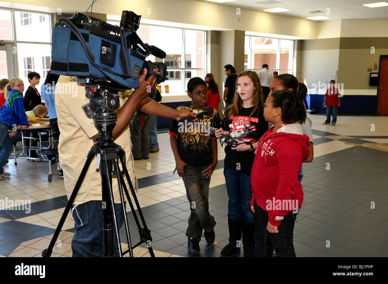 Eine Gruppe von Schulkindern sind von einem TV-Reporter während einer Wissenschaftsmesse interviewt. Stockfoto
