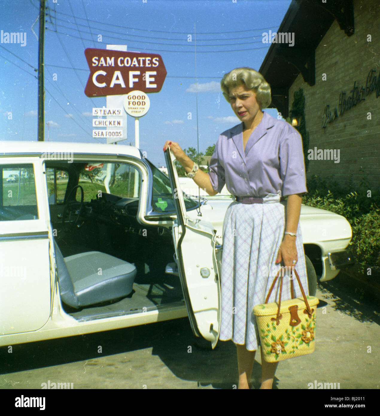 Eine Frau öffnet die Tür ihres Autos außerhalb der Sam Coates Cafe in Waco, Texas in den frühen 1960er Jahren. Stockfoto