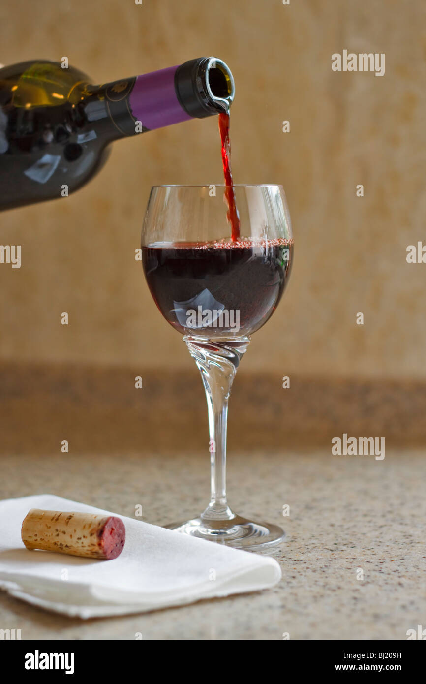 Gießen ein Glas Rotwein Stockfoto