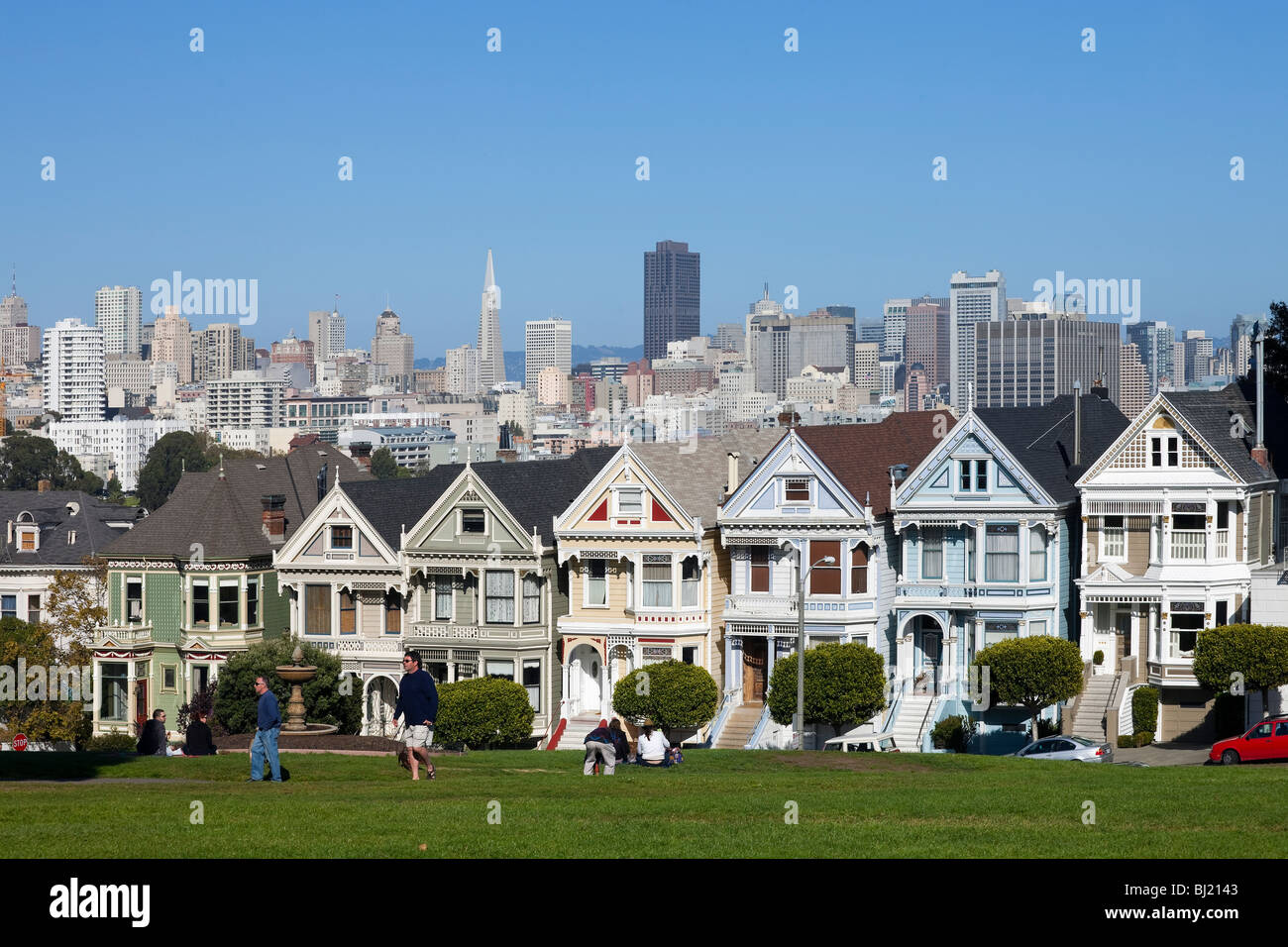 Alamo Square, befindet sich San Francisco.The Painted Ladies Victorian mit Skyline im Hintergrund und Menschen, die Spaß im Vordergrund Stockfoto