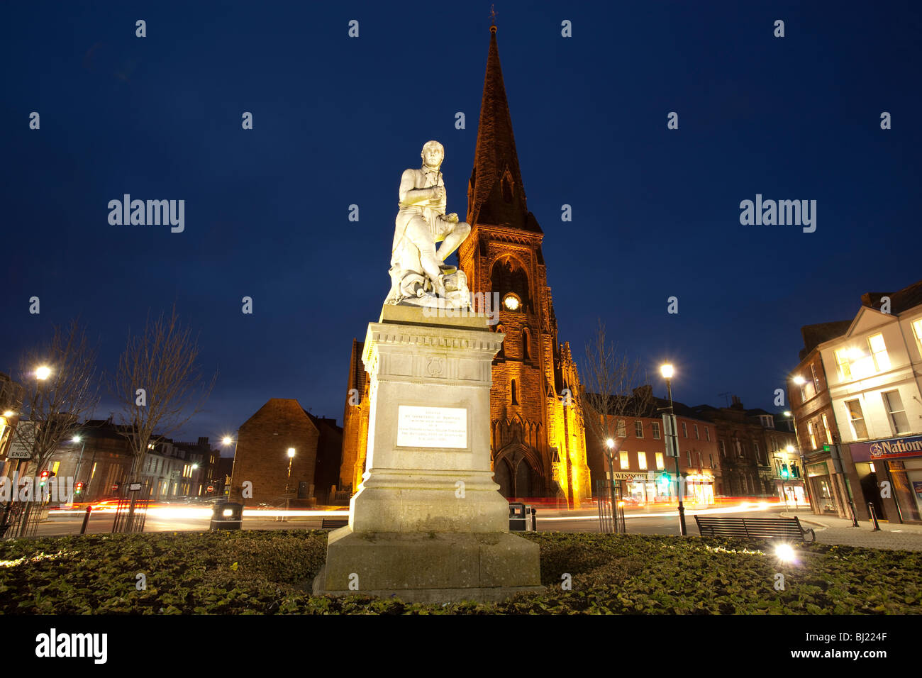 Der Dichter Robert Burns Statue in Dumfries Stadtzentrum mit Greyfriars Kirche hinter nachts Scotland UK Stockfoto