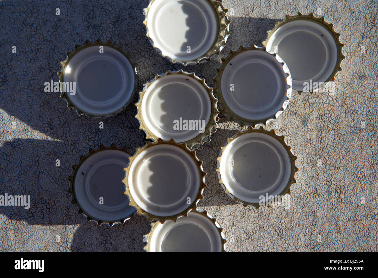Sammlung von Flaschenverschlüssen liegend auf Beton Stockfoto