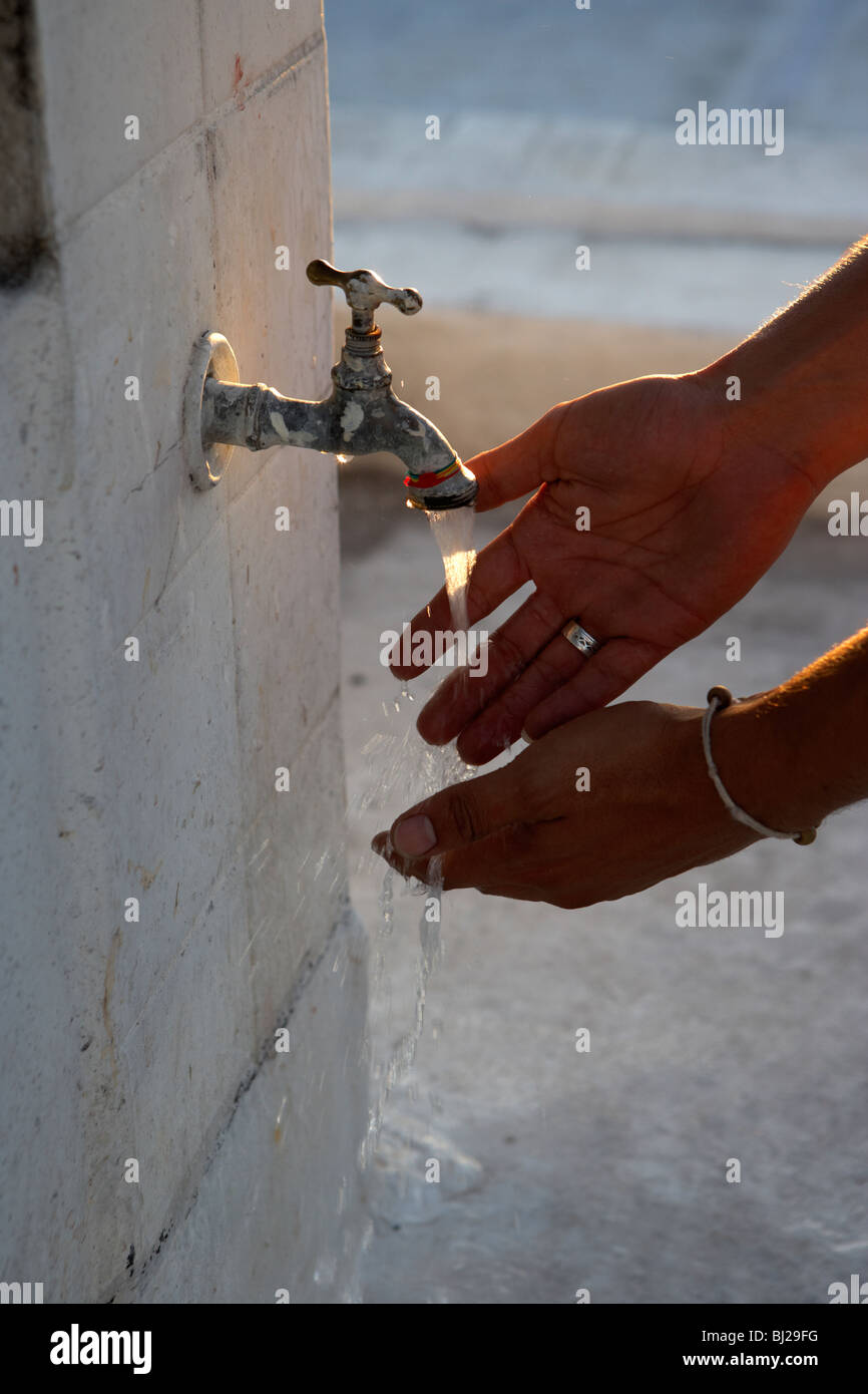 Hispanic Mann Händewaschen an Outdoor-Armatur Stockfoto