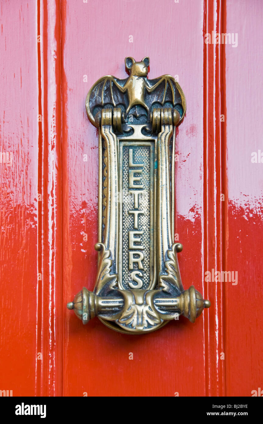Messing-Briefkasten auf rot schmerzte Tür Stockfoto