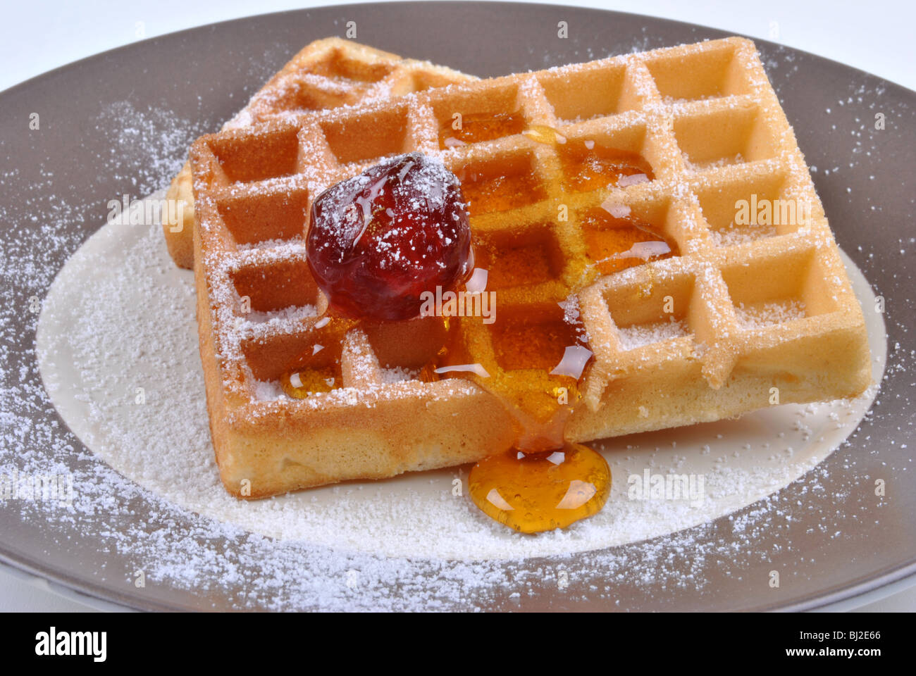 Wafer mit Puderzucker und Kirsche Stockfoto