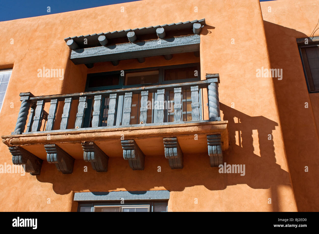 Hölzernen Balkon im zweiten Stock auf rosa Adobe Gebäude in Santa Fe NM Stockfoto