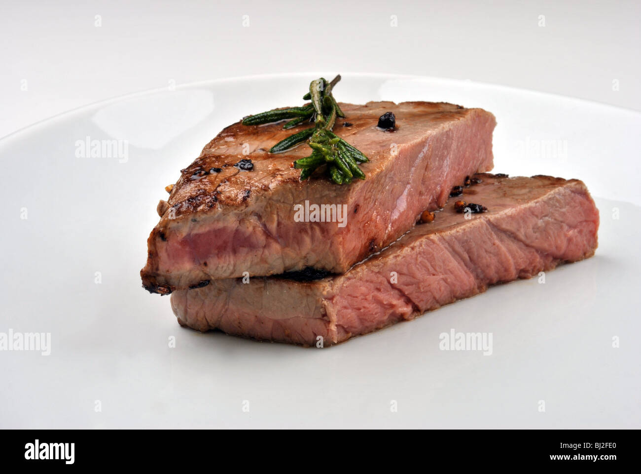 Gegrilltes Steak mit Bio Rosmarin und hellen Hintergrund Stockfoto